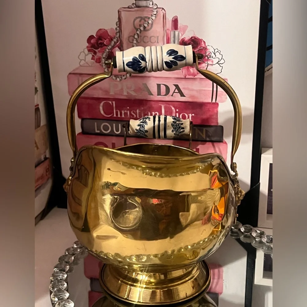 Vintage brass scuttle bucket with a blue and white ceramic handle and lion head
